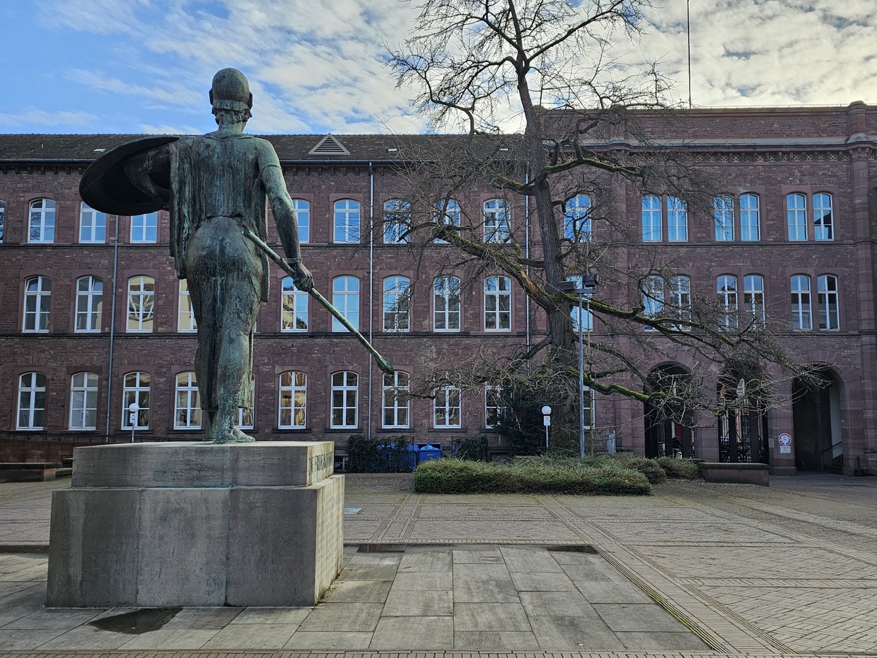 Pallas Athene von hinten mit Blick auf den Baum und ein Gebäude im Ehrenhof