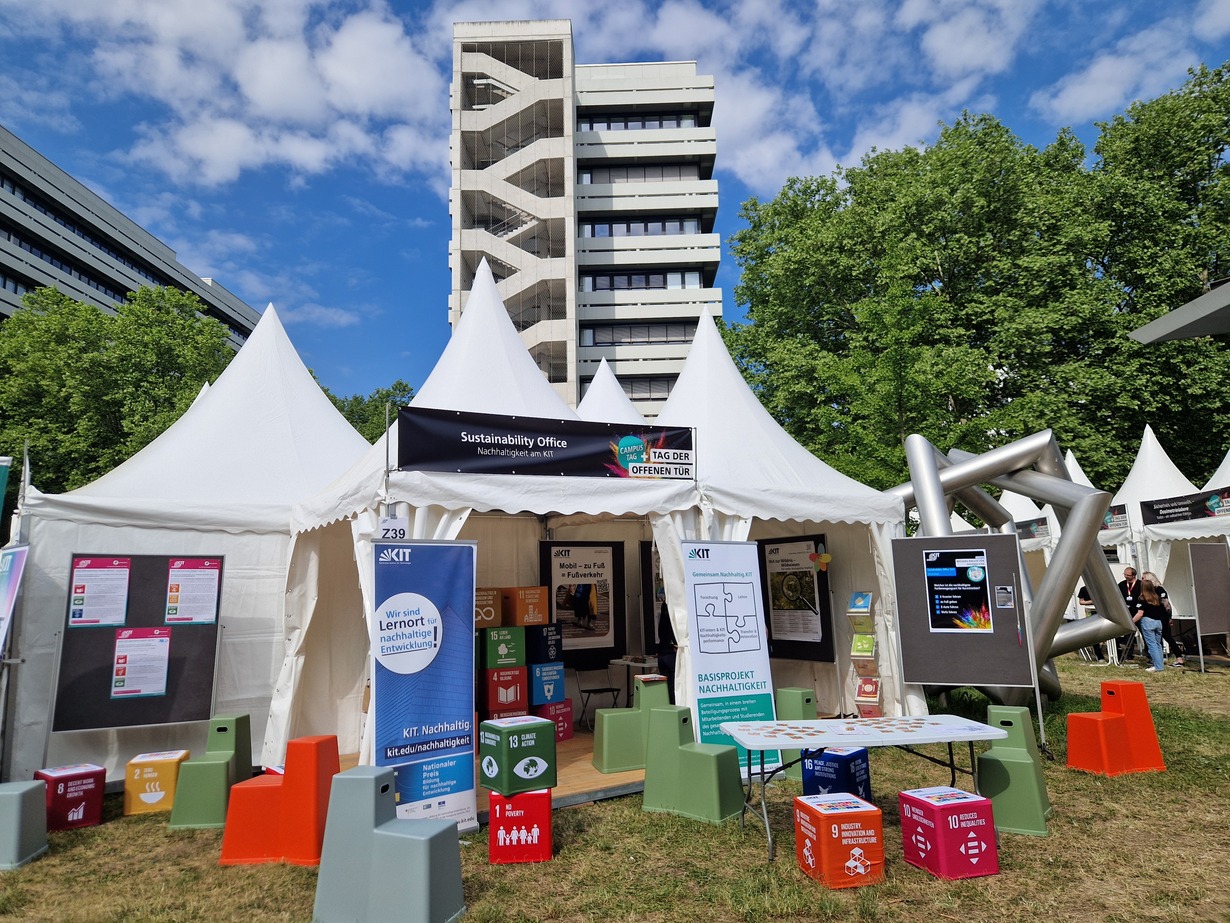 Zelt mit Informationsstand zur Nachhaltigkeit bei einer Veranstaltung im Freien.